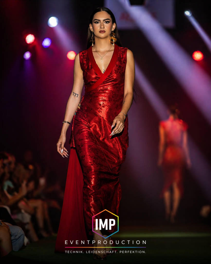 Model im roten Kleid auf Laufsteg mit professioneller Lichttechnik – Fashion Show Eventtechnik von IMP Event Production